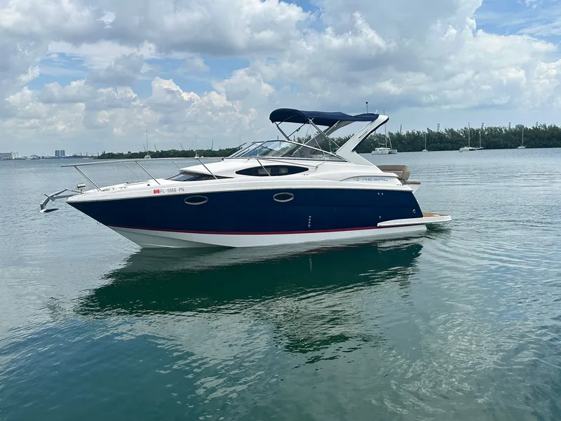 The Image of A 2014 Regal 30 Express boat on calm water with a blue hull and white deck. - 0