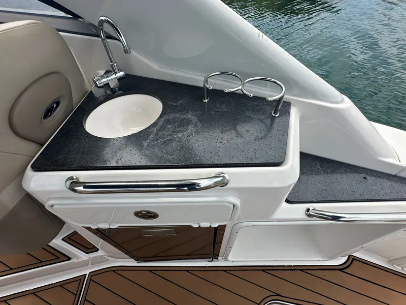 Slide: The Image of The 2014 Regal 30 Express features a compact outdoor kitchenette with a sink and storage. - 15