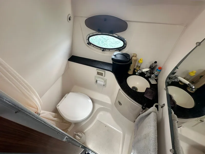 Slide: The Image of The image shows a boat bathroom with a toilet, sink, and porthole. - 26
