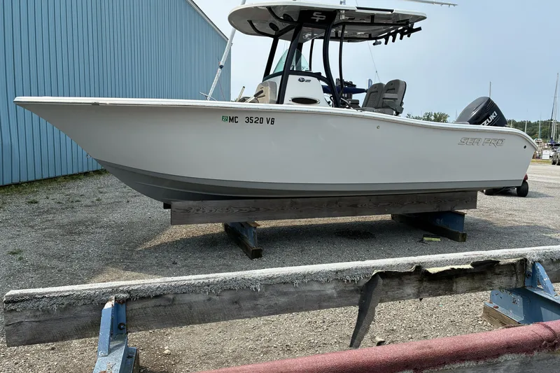 Slide: The Image of 2023 Sea Pro 242 Center Console boat on display, parked on a stand outdoors. - 9