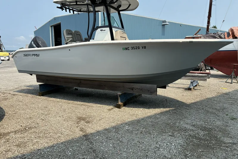 The Image of 2023 Sea Pro 242 Center Console boat on display in a marina setting. - 1