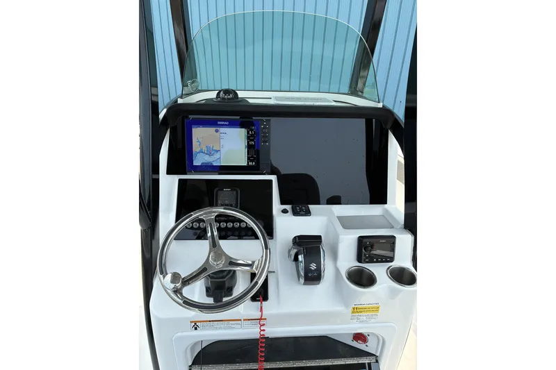 Slide: The Image of 2023 Sea Pro 242 Center Console helm with steering wheel, navigation display, and controls. - 8