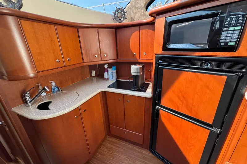Slide: The Image of 2005 Silverton 34 Convertible yacht kitchen with wood cabinets, sink, and appliances. - 38