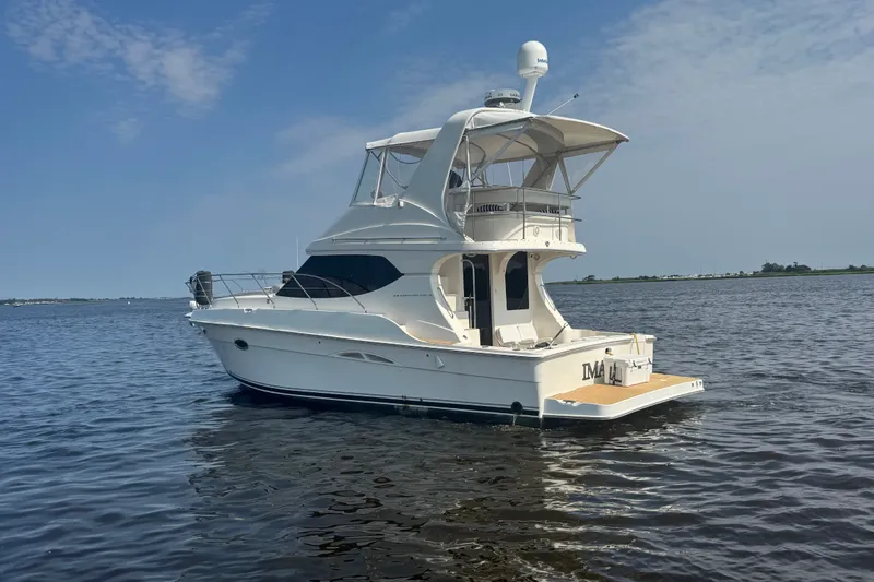 Slide: The Image of 2005 Silverton 34 Convertible yacht on calm water under a clear blue sky. - 15