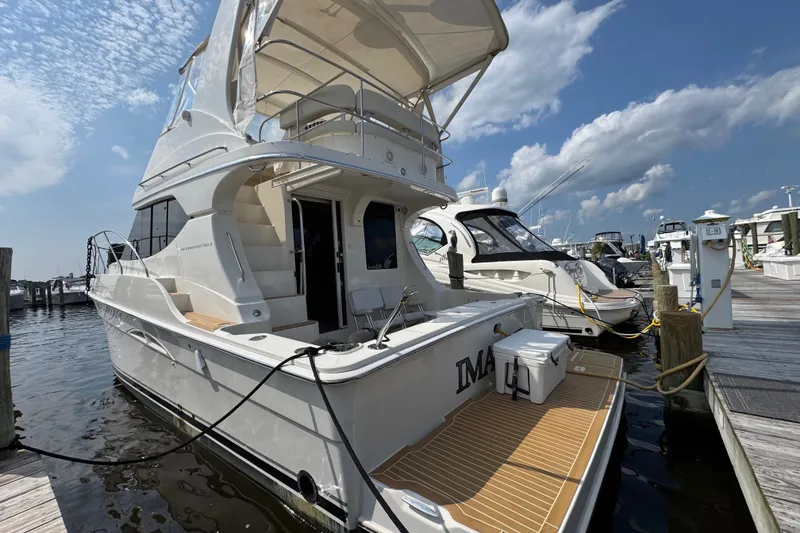 Slide: The Image of 2005 Silverton 34 Convertible yacht docked at marina under blue sky. - 17