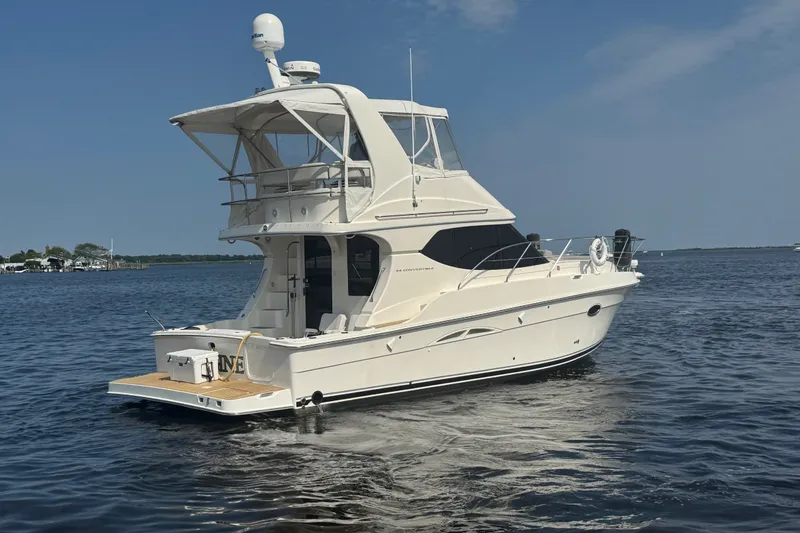Slide: The Image of 2005 Silverton 34 Convertible yacht cruising on calm waters under a clear blue sky. - 11