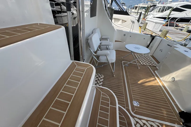 Slide: The Image of 2005 Silverton 34 Convertible yacht deck with seating and table, docked at marina. - 21
