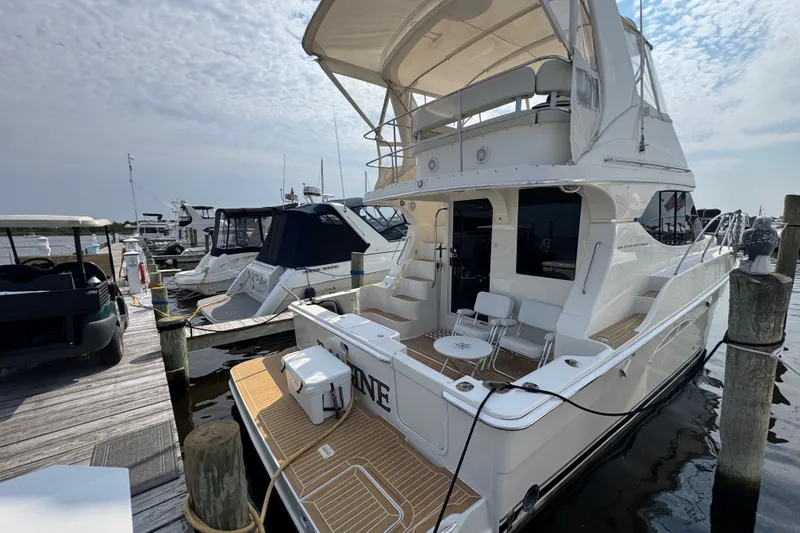 Slide: The Image of 2005 Silverton 34 Convertible yacht docked at marina under cloudy sky. - 19