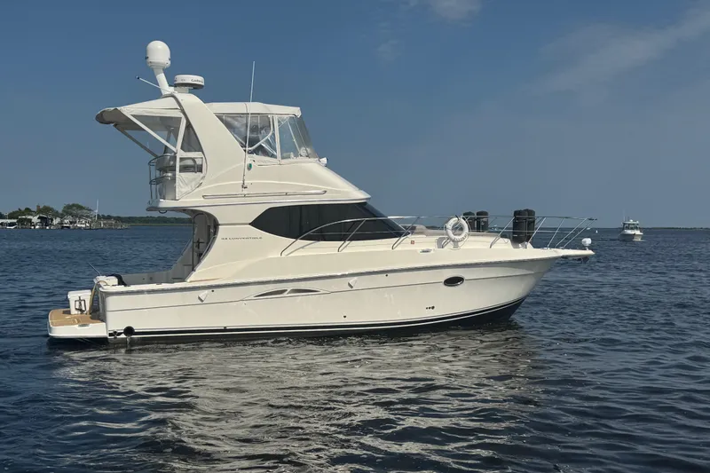 Slide: The Image of 2005 Silverton 34 Convertible yacht cruising on open water under clear skies. - 12