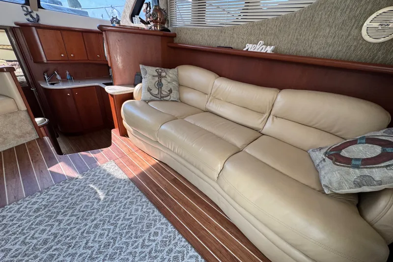 Slide: The Image of Luxurious interior of 2005 Silverton 34 Convertible yacht with beige leather sofa and nautical decor. - 34