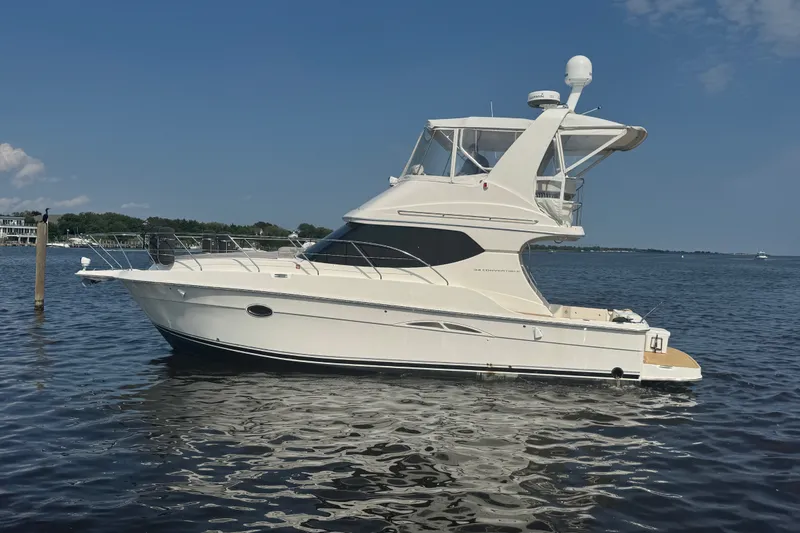 Slide: The Image of 2005 Silverton 34 Convertible yacht on calm water under a clear blue sky. - 14
