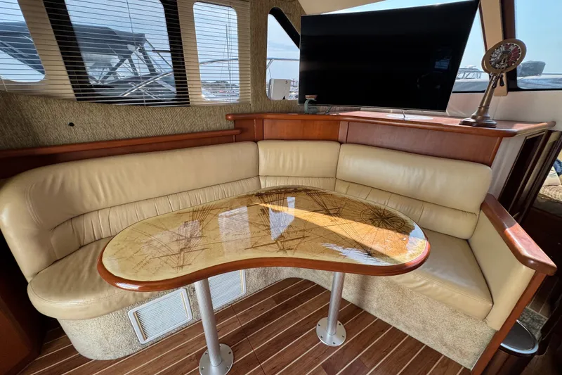 Slide: The Image of Interior of 2005 Silverton 34 Convertible yacht with leather seating and nautical-themed table. - 32