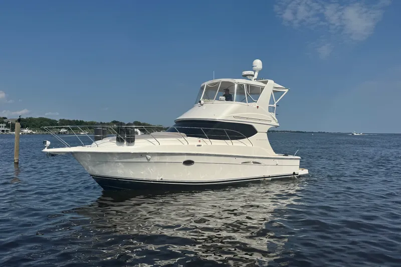 Slide: The Image of 2005 Silverton 34 Convertible yacht on calm water under clear blue sky. - 10