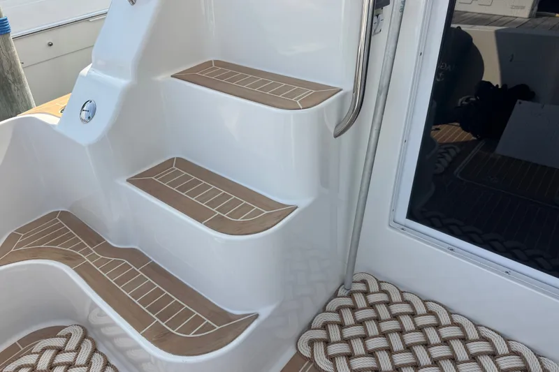 Slide: The Image of Staircase on 2005 Silverton 34 Convertible yacht with teak-style steps and rope mat. - 24