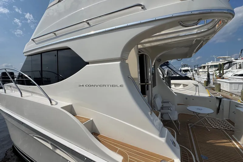 Slide: The Image of 2005 Silverton 34 Convertible yacht docked, showcasing sleek design and spacious deck area. - 18