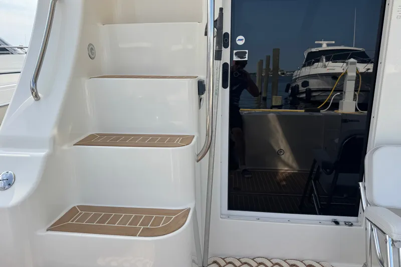 Slide: The Image of 2005 Silverton 34 Convertible yacht with sleek stairs and glass door, docked at marina. - 22