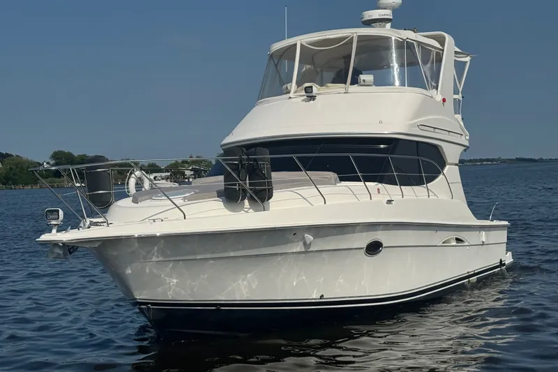 The Image of 2005 Silverton 34 Convertible yacht on calm water, showcasing sleek design and spacious deck. - 8