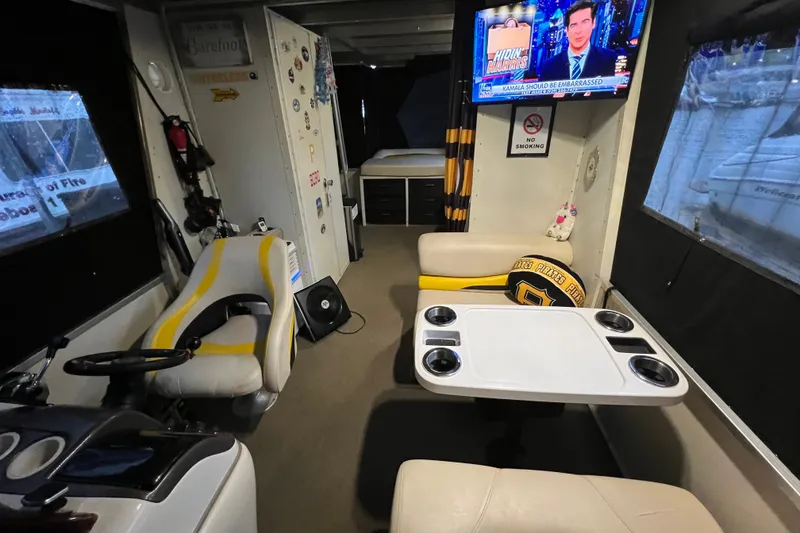 Slide: The Image of Interior of 2007 TRACKER MARINE Party Hut 30 with seating, table, and TV. - 16