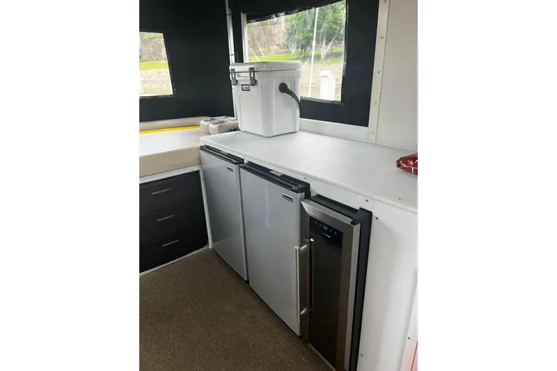 Slide: The Image of 2007 TRACKER MARINE Party Hut 30 interior with fridge and storage cabinets. - 15