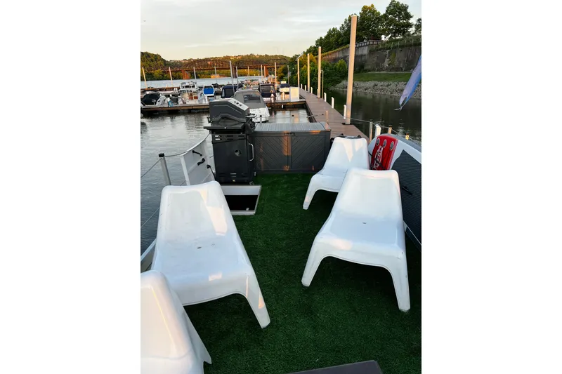 Slide: The Image of 2007 Sun Tracker Party Hut 30 Regency Edition with white chairs on deck by the dock. - 21