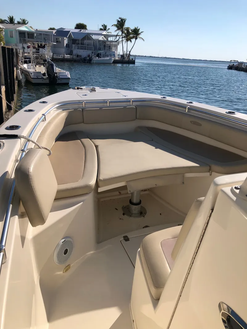Slide: The Image of The image shows the bow area of a 2016 Cobia 296 Center Console boat with beige cushions. - 6