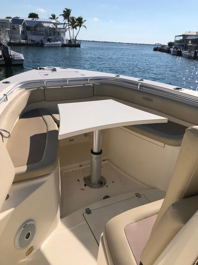 Slide: The Image of The image shows the cockpit of a 2016 Cobia 296 Center Console boat with a table. - 7