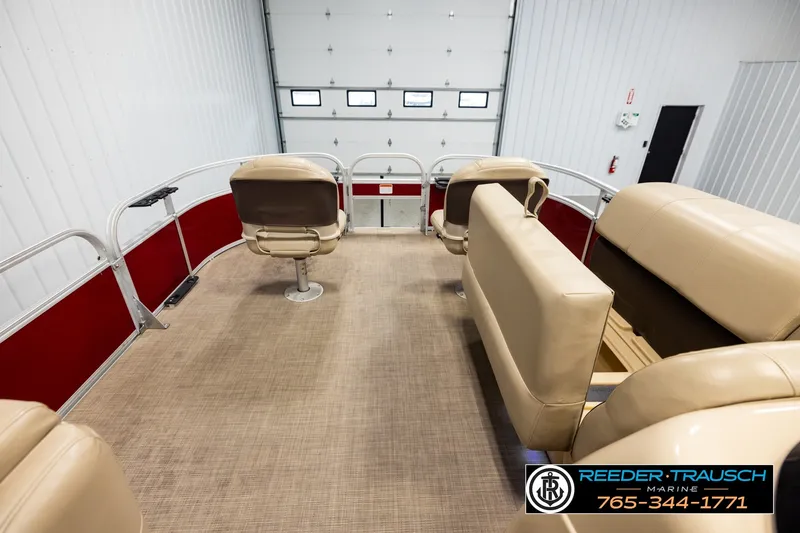 Slide: The Image of 2019 SUNTRACKER 20 DLX pontoon boat interior with beige seating and red accents. - 19