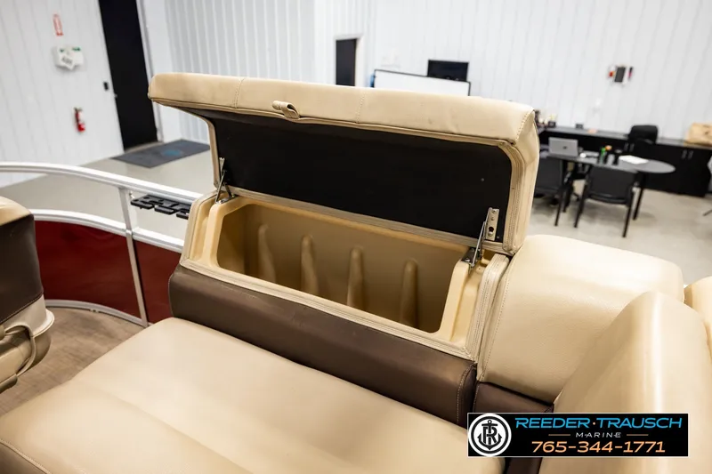 Slide: The Image of Open storage compartment on 2019 SUNTRACKER 20 DLX boat, beige seating, indoor showroom. - 20