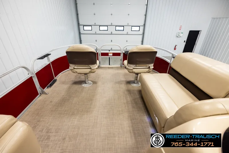 Slide: The Image of 2019 SUNTRACKER 20 DLX pontoon boat interior with beige seating and red accents. - 18