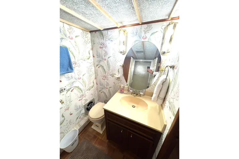 Slide: The Image of 1982 Pluckebaum Coastal Cruiser bathroom with floral wallpaper, oval mirror, and beige sink. - 35
