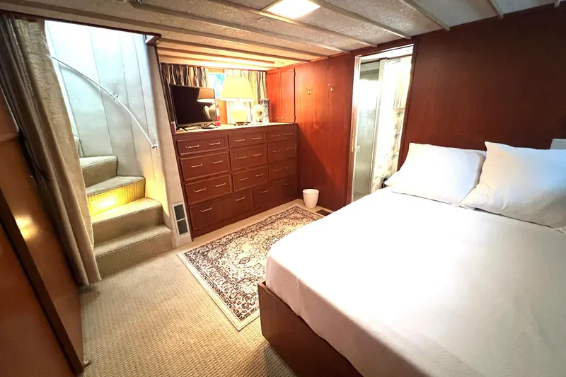 Slide: The Image of Cozy bedroom in 1982 Pluckebaum Coastal Cruiser with wooden cabinetry and carpeted stairs. - 31