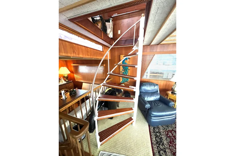 Slide: The Image of Interior of 1982 Pluckebaum Coastal Cruiser with wooden spiral staircase and cozy seating area. - 38