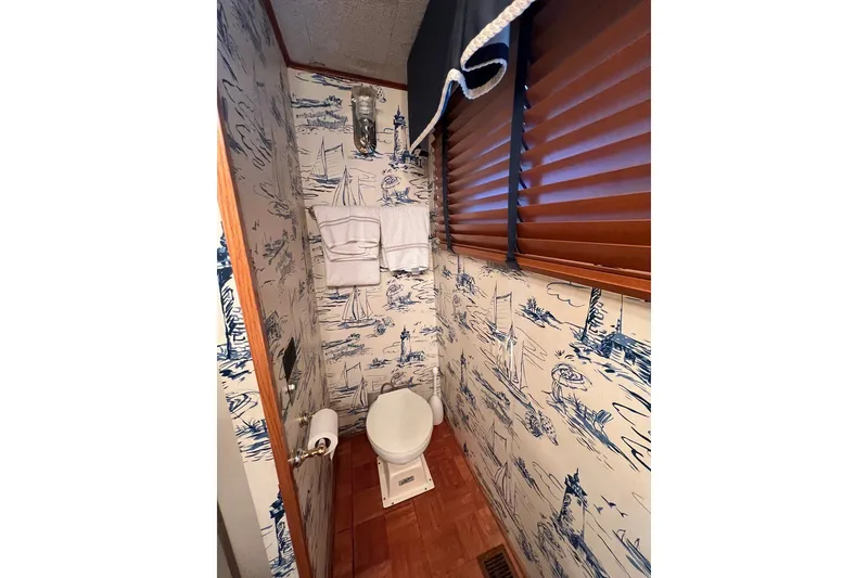 Slide: The Image of 1982 Pluckebaum Coastal Cruiser bathroom with nautical-themed wallpaper and wooden blinds. - 28
