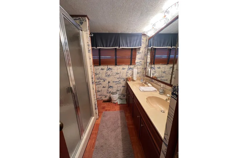 Slide: The Image of Bathroom in 1982 Pluckebaum Coastal Cruiser with nautical wallpaper and dual sinks. - 26