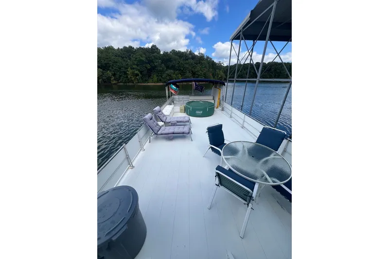 Slide: The Image of 1982 Pluckebaum Coastal Cruiser deck with chairs, table, and scenic water view. - 43