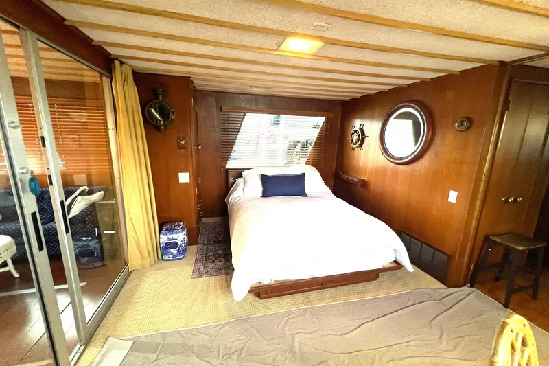 Slide: The Image of Cozy bedroom in 1982 Pluckebaum Coastal Cruiser with nautical decor and wooden paneling. - 22