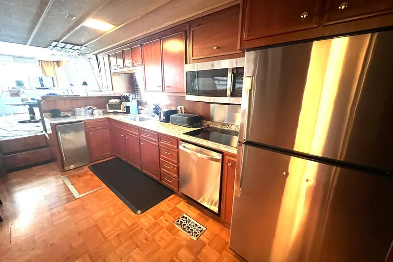Slide: The Image of 1982 Pluckebaum Coastal Cruiser kitchen with stainless steel appliances and wooden cabinetry. - 19