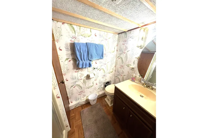 Slide: The Image of Bathroom in 1982 Pluckebaum Coastal Cruiser with floral wallpaper and wooden vanity. - 36