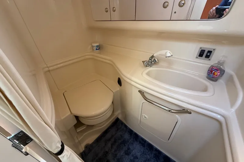 Slide: The Image of 2004 Sea Ray 340 Sundancer bathroom with sink, toilet, and storage cabinets. - 32