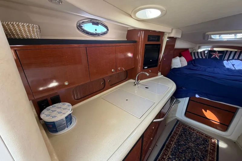 Slide: The Image of Interior of 2004 Sea Ray 340 Sundancer with kitchenette and cozy sleeping area. - 16