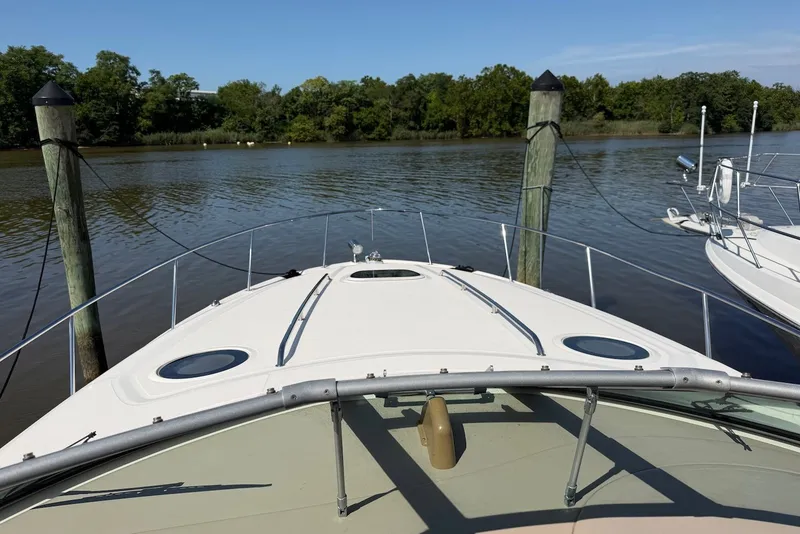 Slide: The Image of 2004 Sea Ray 340 Sundancer docked on a calm river with lush greenery. - 3