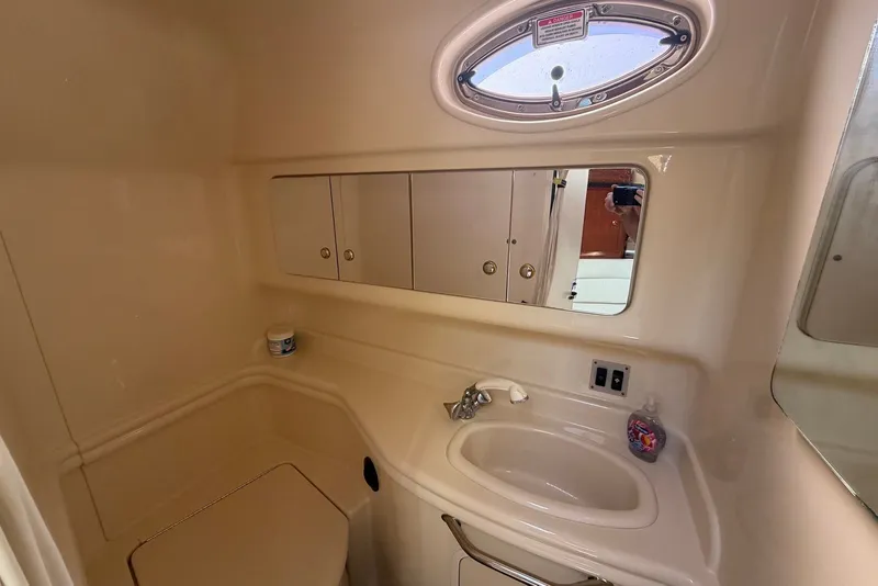Slide: The Image of 2004 Sea Ray 340 Sundancer bathroom with sink, mirror, and storage cabinets. - 33