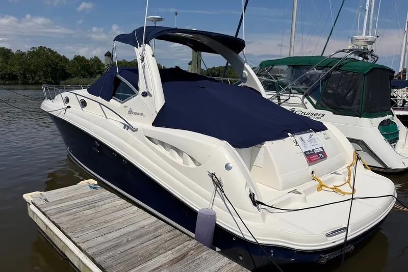 Slide: The Image of 2004 Sea Ray 340 Sundancer yacht docked at marina, featuring sleek design and navy cover. - 1
