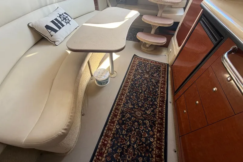 Slide: The Image of Interior of 2004 Sea Ray 340 Sundancer with seating, table, and decorative rug. - 20