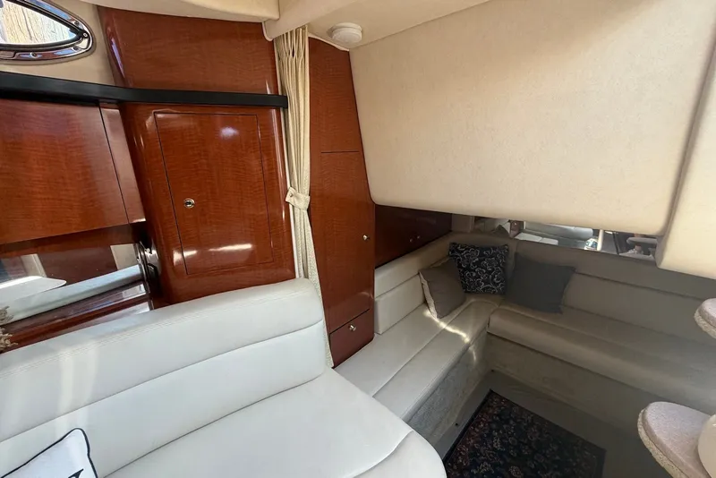 Slide: The Image of Interior of 2004 Sea Ray 340 Sundancer yacht with plush seating and wooden cabinetry. - 21