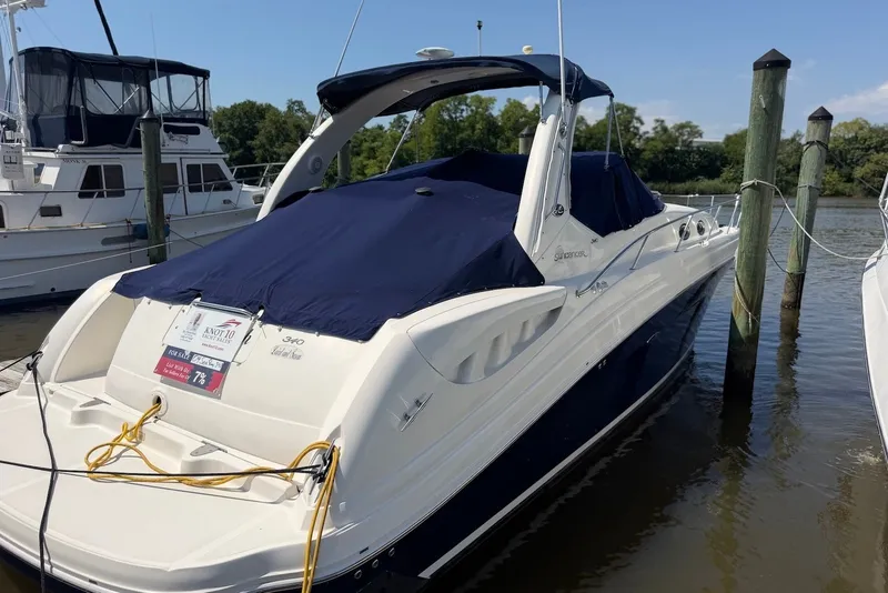Slide: The Image of 2004 Sea Ray 340 Sundancer docked, covered with navy blue canvas, for sale sign visible. - 2