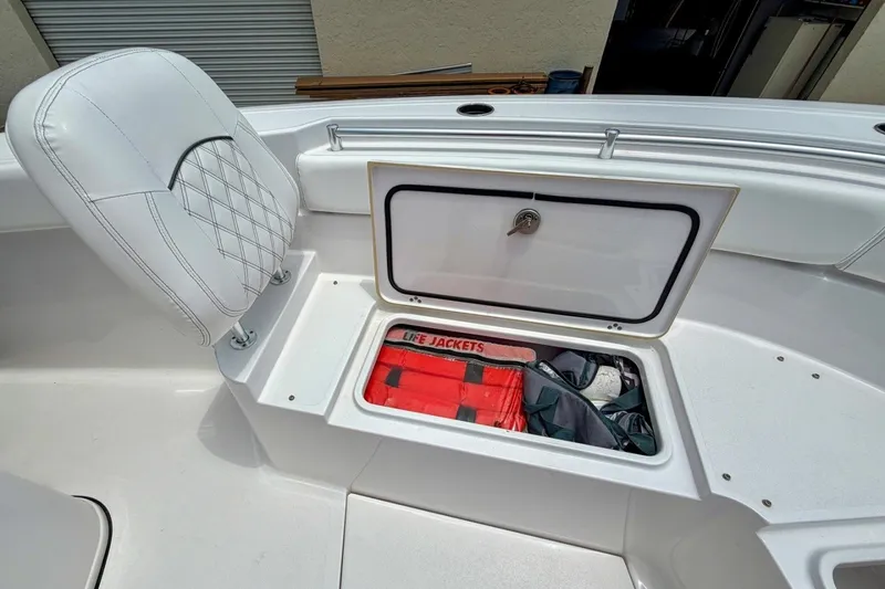 Slide: The Image of 2023 Sportsman Heritage 261 Center Console storage with life jackets and cushioned seat. - 44