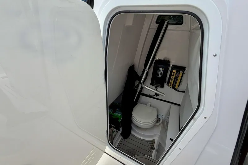Slide: The Image of 2023 Sportsman Heritage 261 Center Console boat interior with toilet and storage. - 53