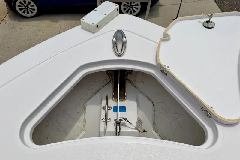 Slide: The Image of 2023 Sportsman Heritage 261 Center Console anchor locker, open lid, and visible anchor mechanism. - 40