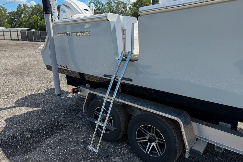 Slide: The Image of 2023 Sportsman Heritage 261 Center Console on trailer with ladder, parked outdoors. - 7